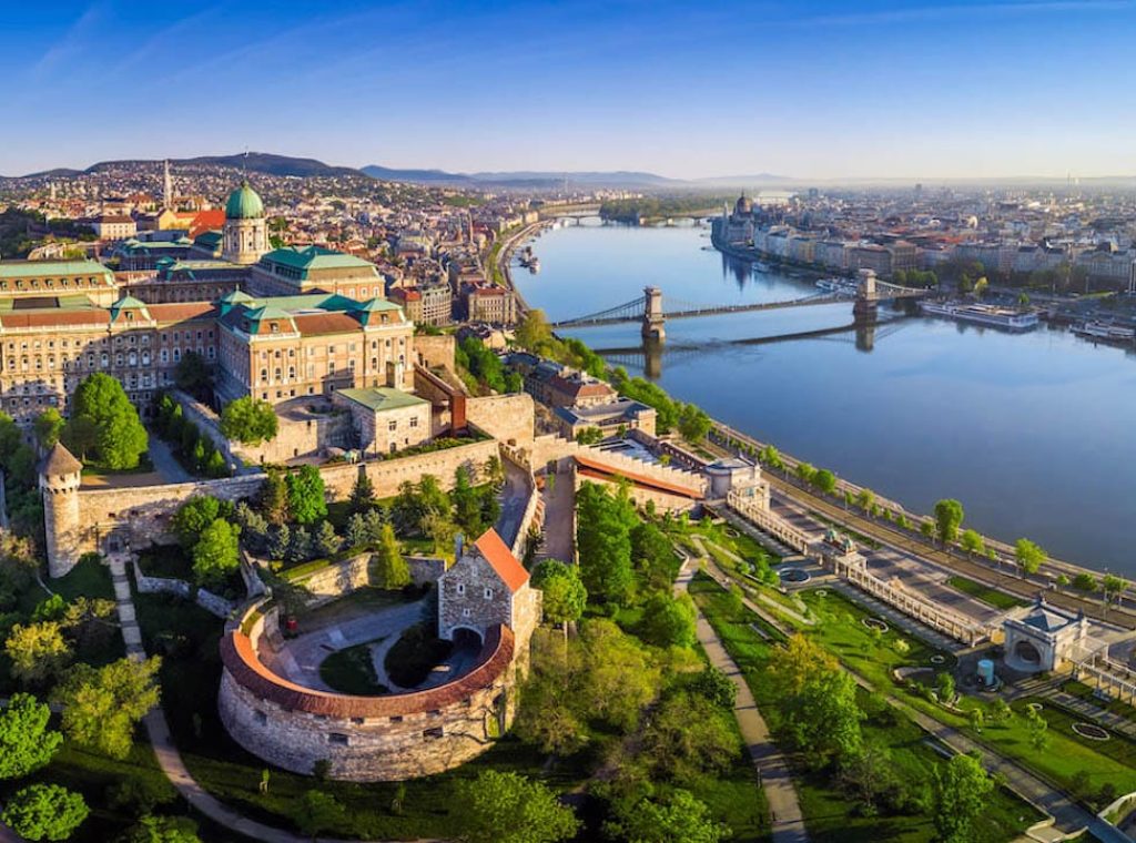 Budapest, Hungary - Aerial panoramic skyline view of Buda Castle Royal Palace with Szechenyi Chain Bridge, St.Stephen's Basilica, Hungarian Parliament and Matthias Church at sunrise with blue sky