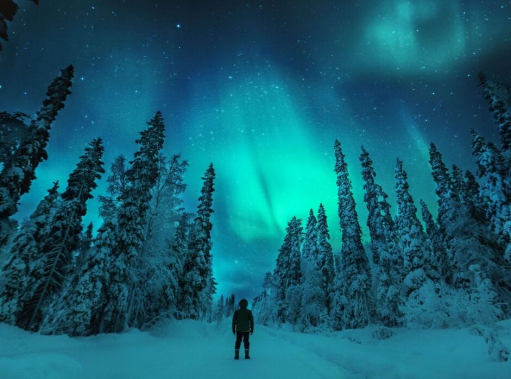 Man watching Aurora borealis in lapland winter